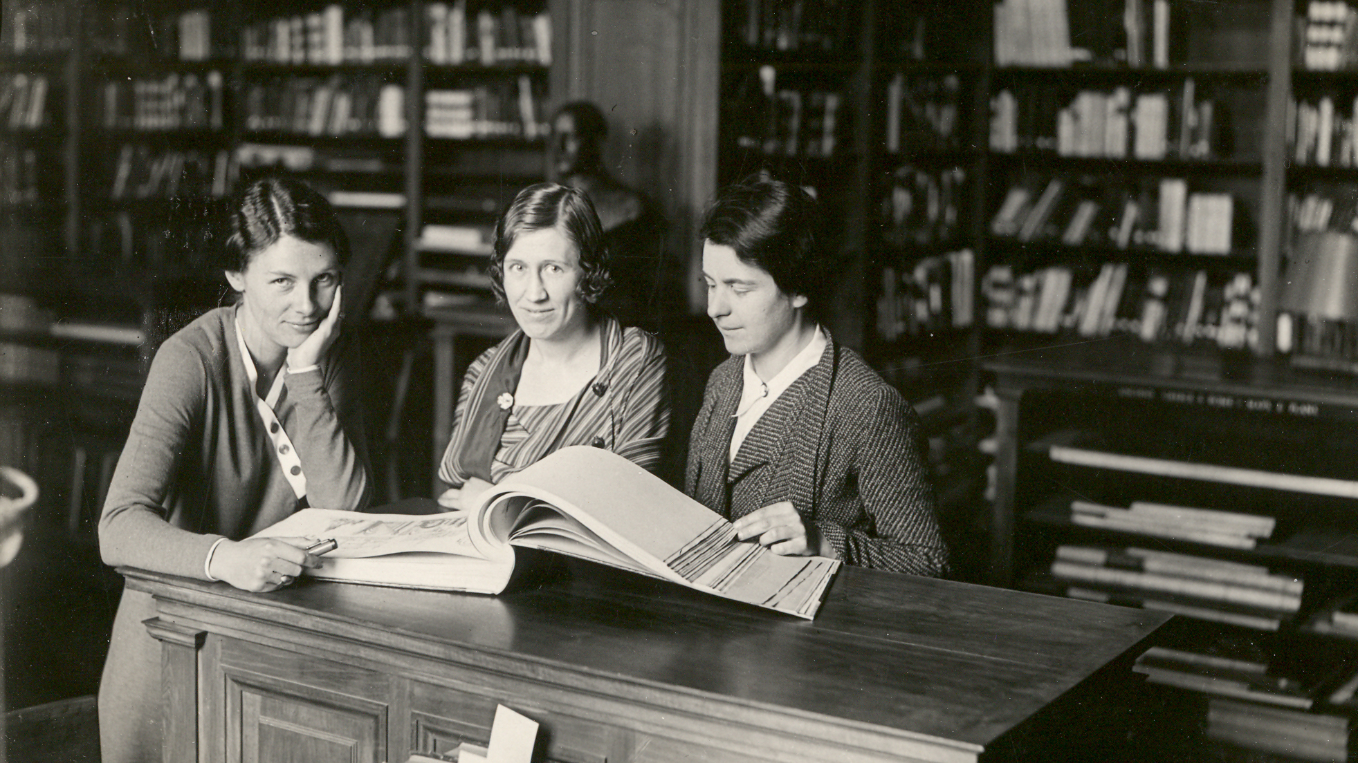 1933 Library Women Black and white photo of three light skinned women in a library in 1933