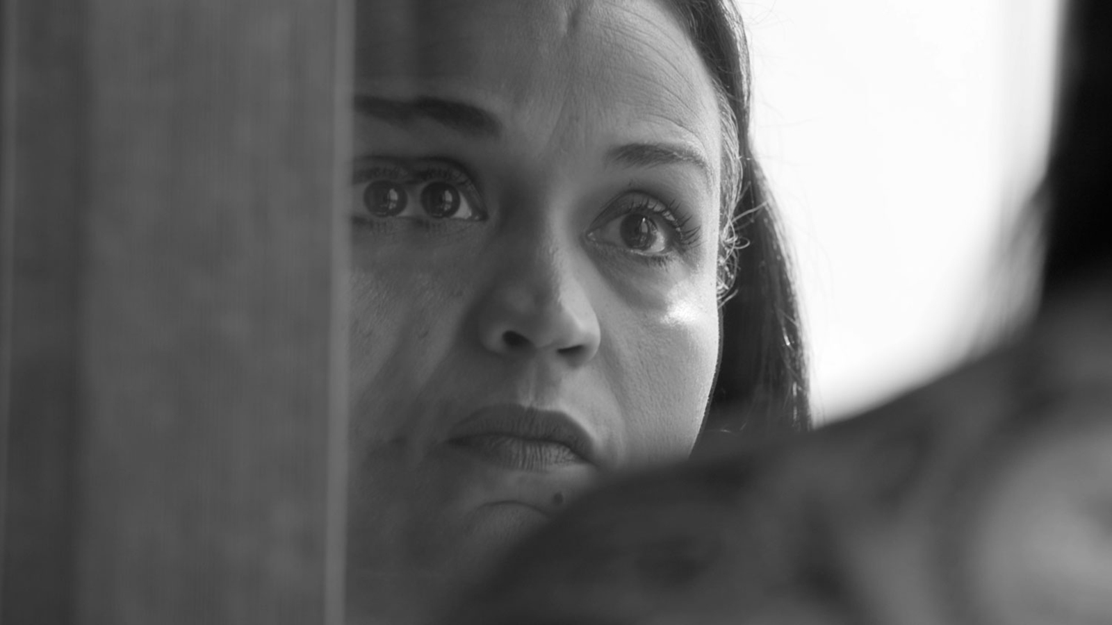 2020 Conversations - A. O. Scott and Garrett Bradley Black and white film still of a closeup of Fox Rich looking into a mirror