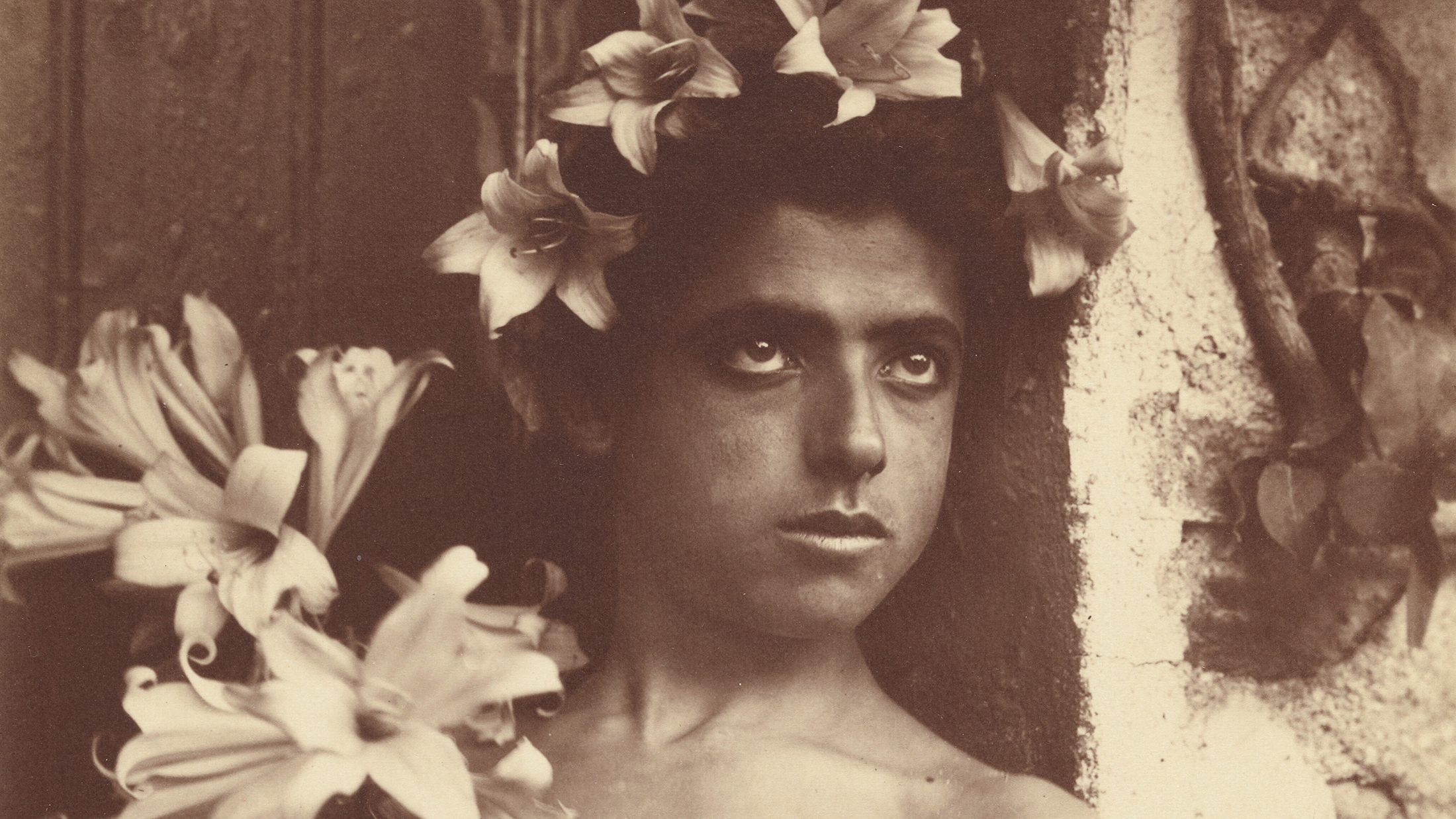Jerome Lectures - Amy Richlin - von Gloeden Monochromatic brown 19th-century photograph of the head of a young boy wearing a floral crown and staring off camera