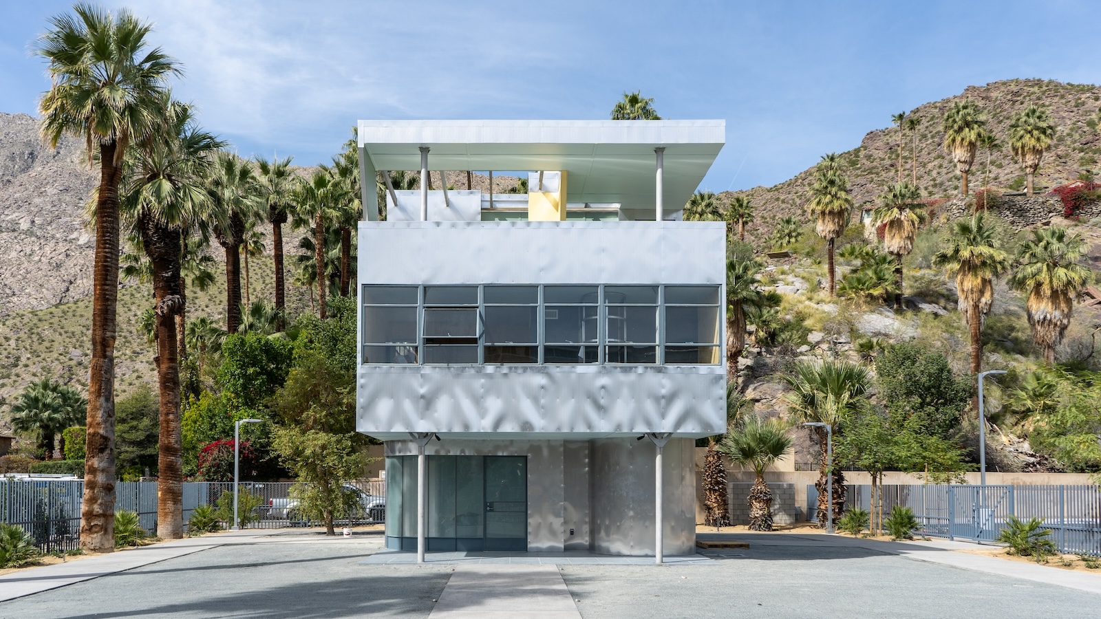 A small modernist house with a desert landscape behind