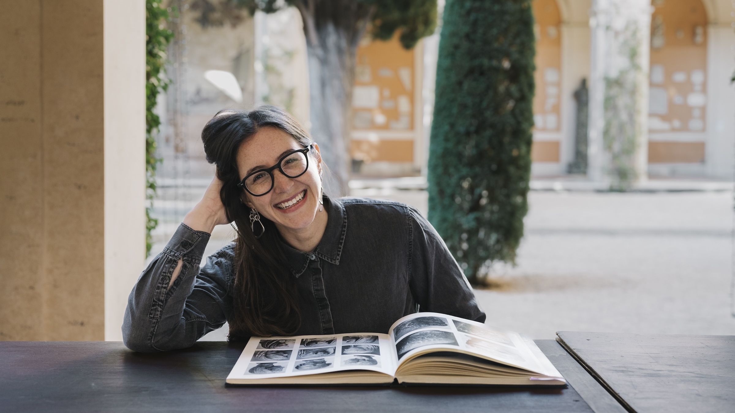 A woman in a courtyard with a book