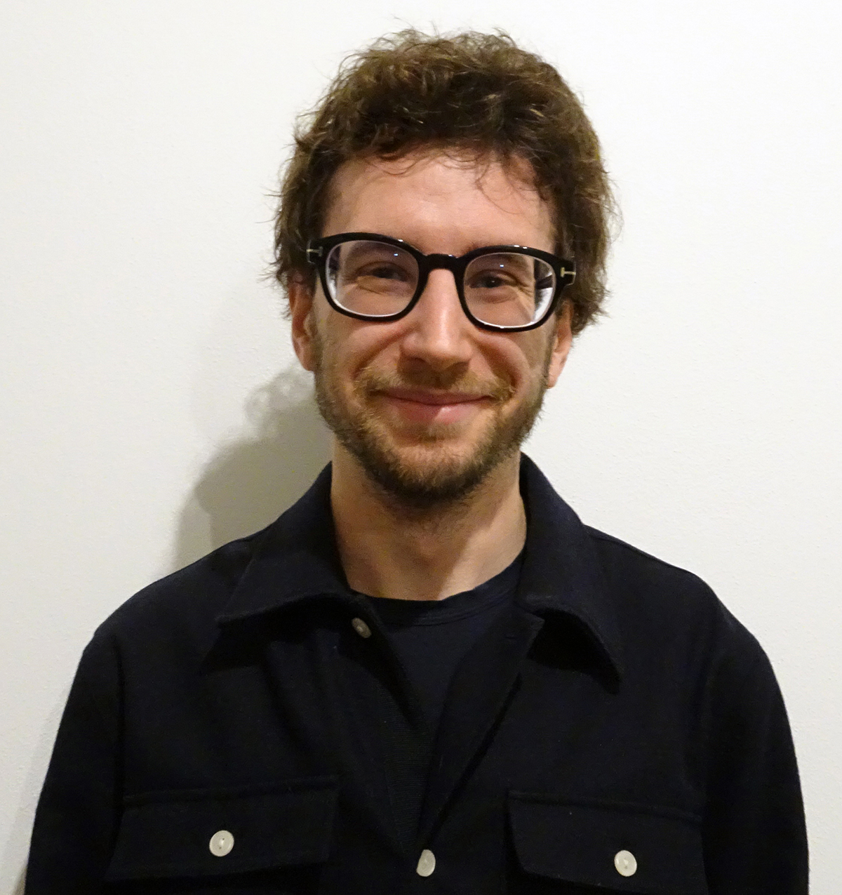 Eugenio Villa Color photo of a light skinned man with dark hair and glasses smiling at the camera