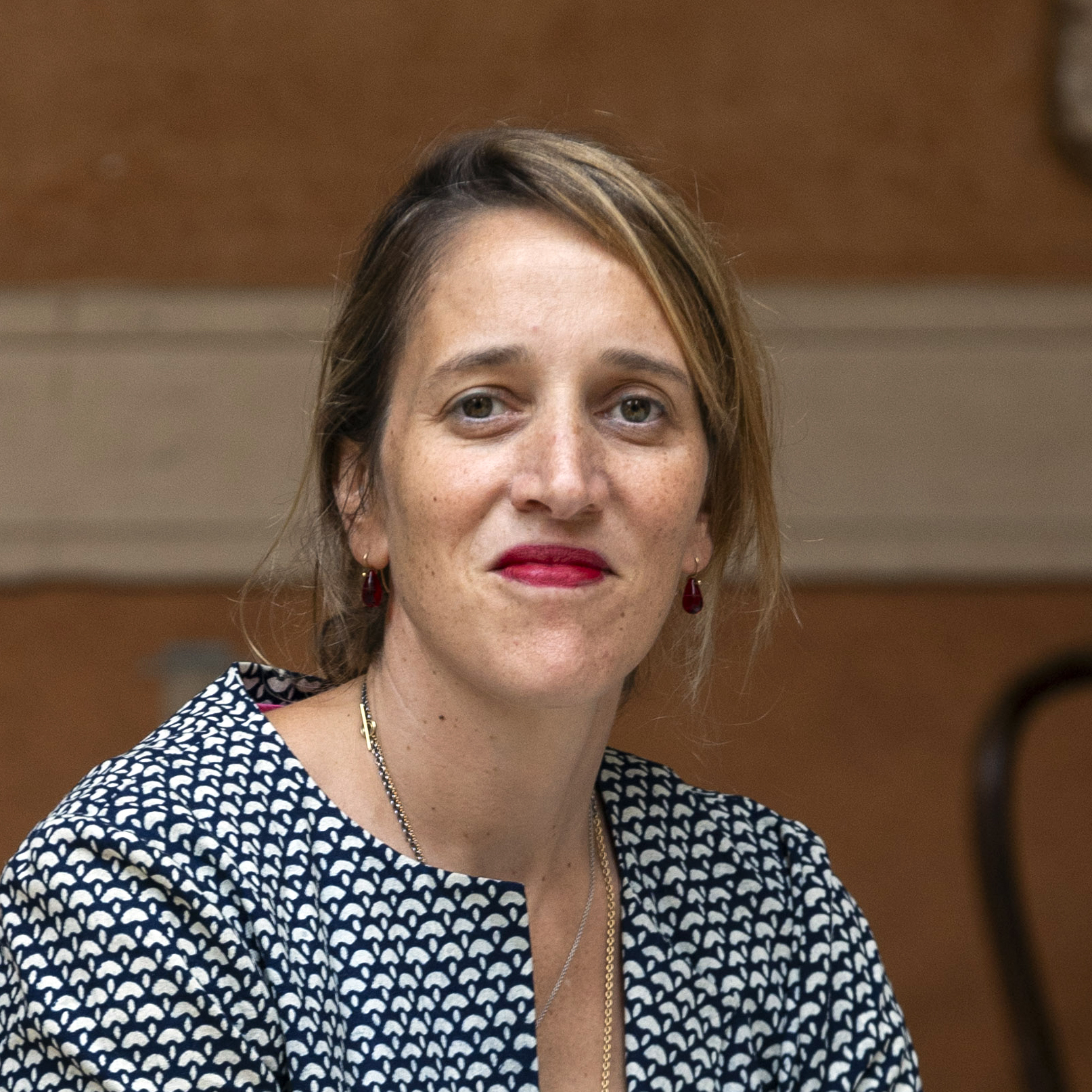 Ilaria Puri Purini Color photograph of a light skinned woman in an Italian courtyard looking at the camera