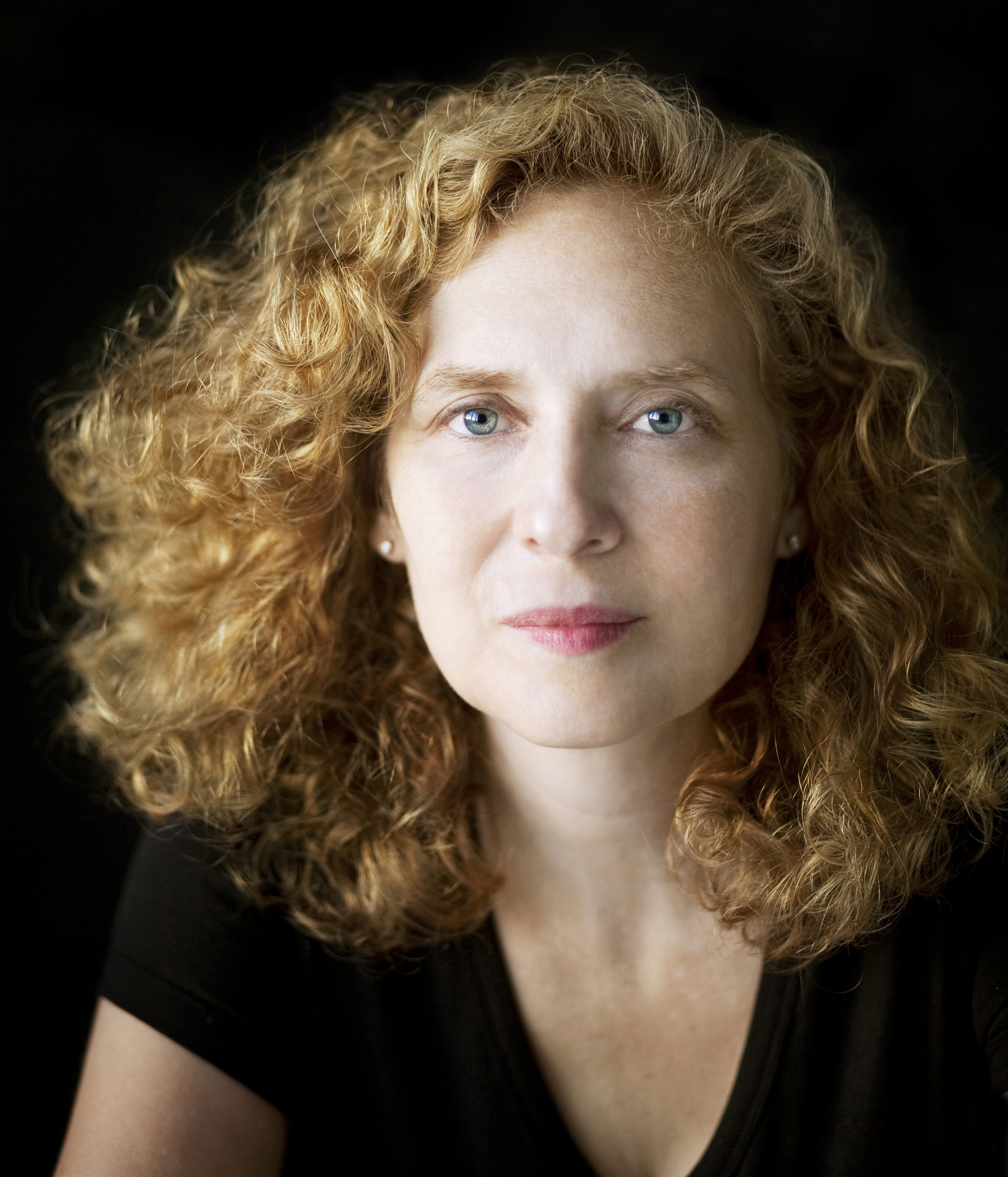 Julia Wolfe Color photo of the head and shoulders of a light skinned woman with reddish hair looking at the camera