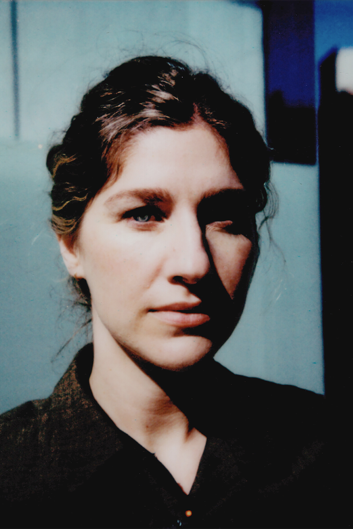 Ketter Weissman Color photo of the head and shoulders of a light skinned woman looking at the camera with a serious expression