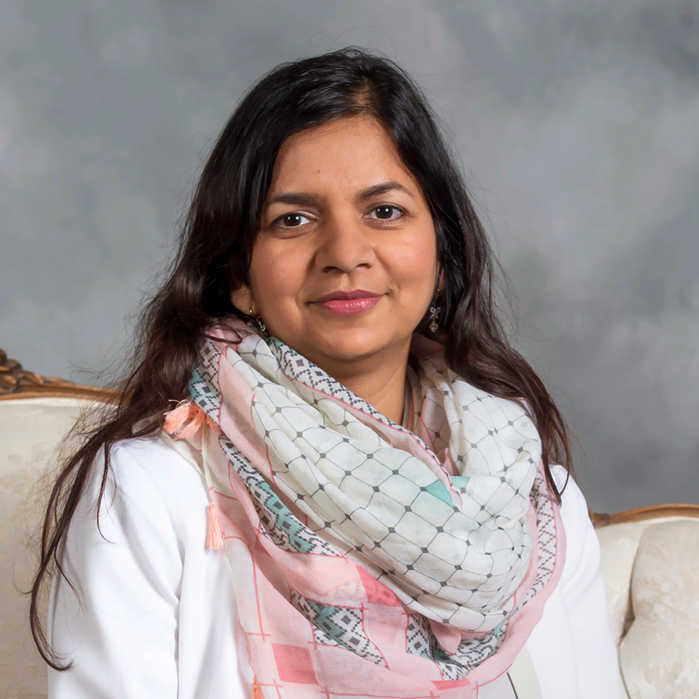 Krupali Krusche Color photo of an Indian woman in a photographer's studio smiling at the camera