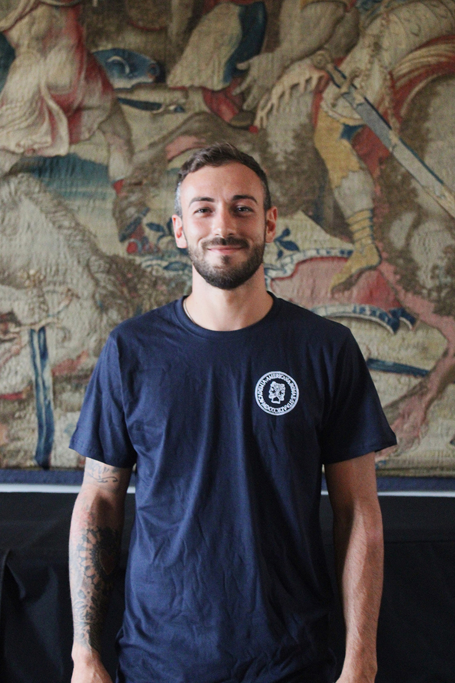 Photograph of a light skinned man wearing a blue shirt facing the camera