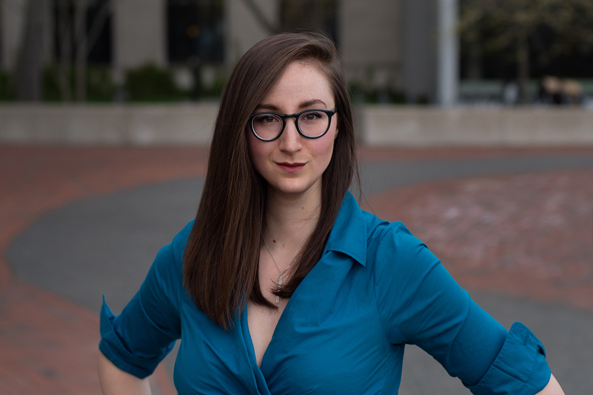 Tina Tallon Color photograph of Tina Tallon standing in an outdoor plaza, with her hands on her hips