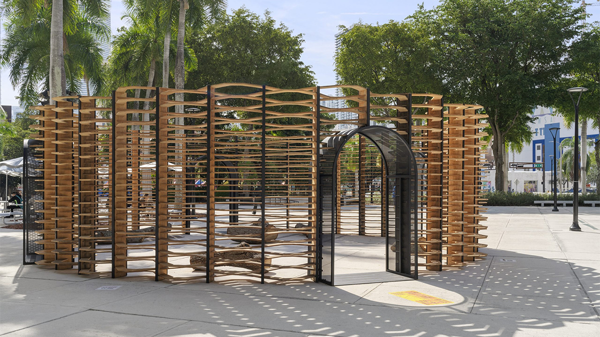 Color photograph of a temporary slotted wood pavilion in a public square in Miami surrounded by palm trees