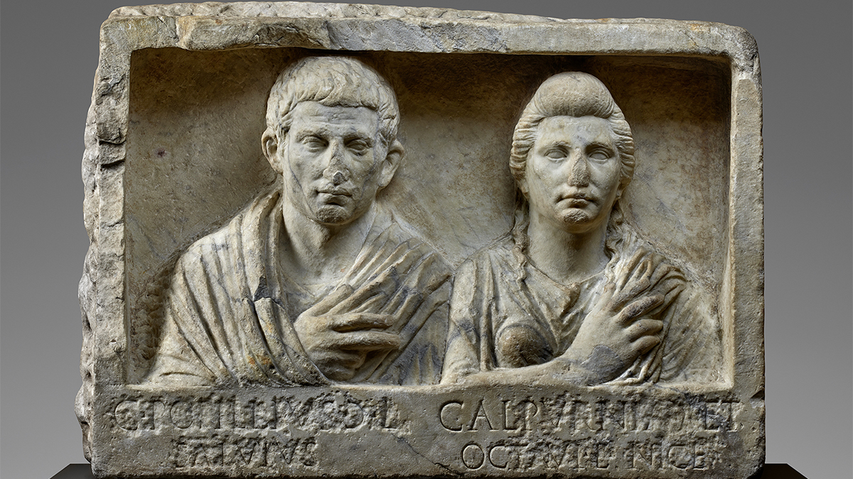 Color photo of an ancient carved stone funerary monument with a man and woman depicted
