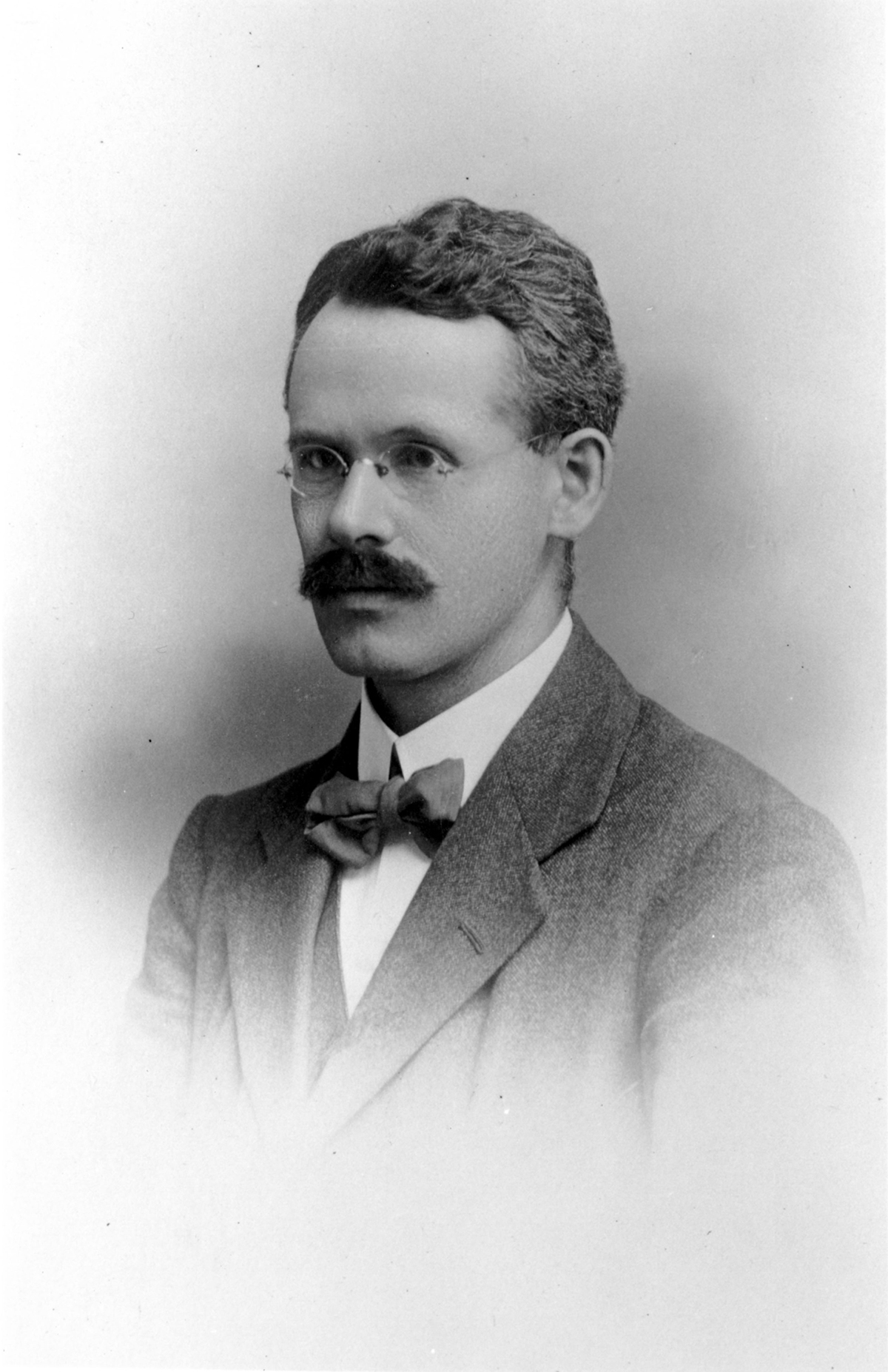 Black and white photo of a light skinned man taken in the early decades of the 20th century