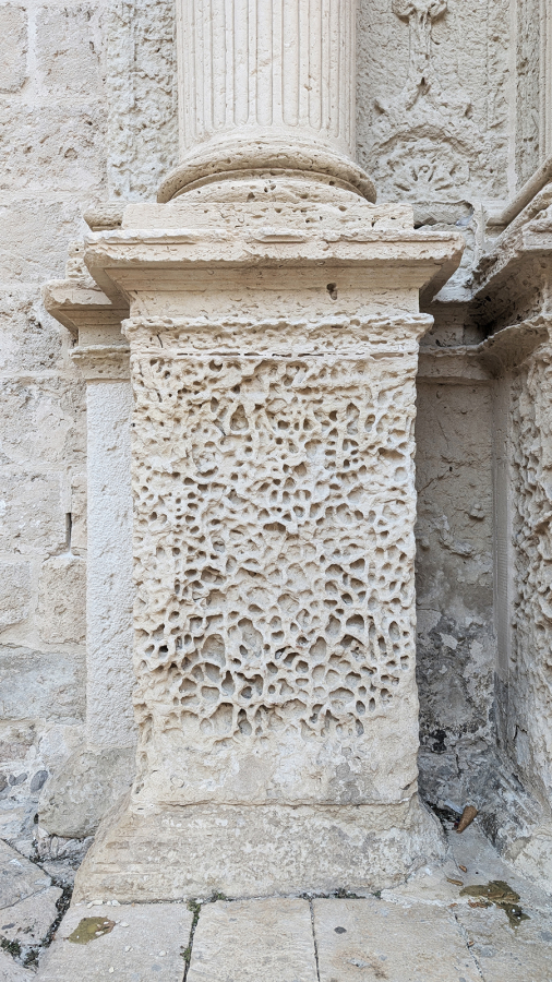 Color photograph of a carved stone pillar and base