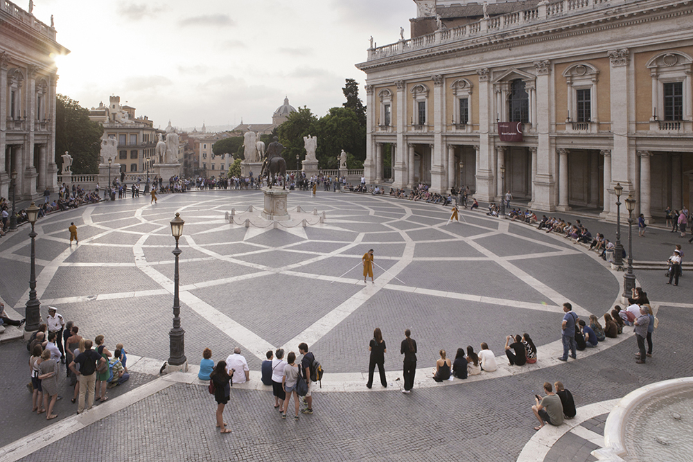 Color photograph of Bryony Roberts's performance at the Piazza del Campidoglio in Rome, with performers on the plaza surrounded by onlookers