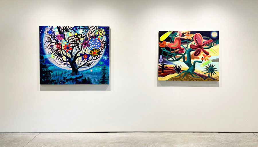 Color photograph of two medium sized paintings hanging on a white gallery wall; both paintings depict trees and plants in bright colors and exaggerated forms