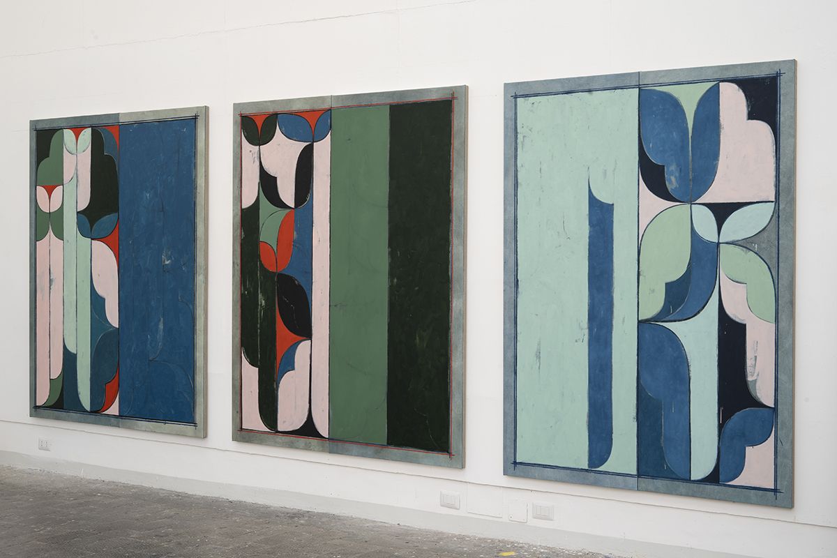 Color photo of three colorful abstract paintings of the same size hanging on a wall