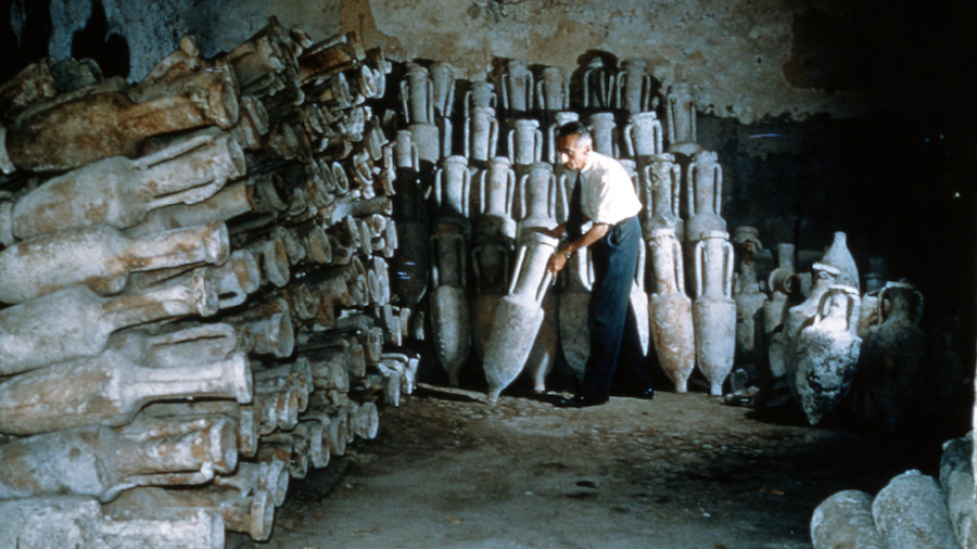 A man inspecting amphorae