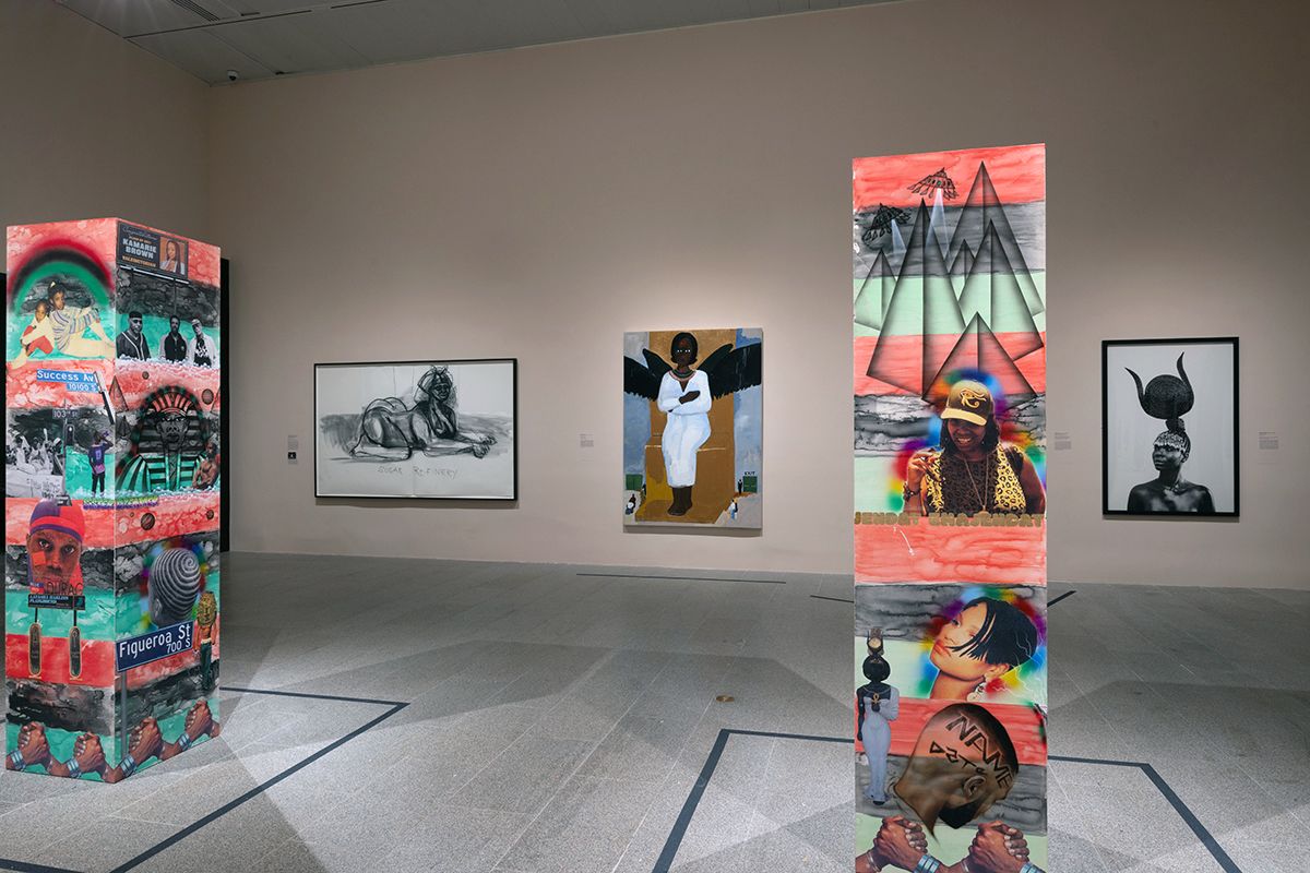 Color photo of an installation of a museum exhibition with various sculptures, paintings, and drawings in the room