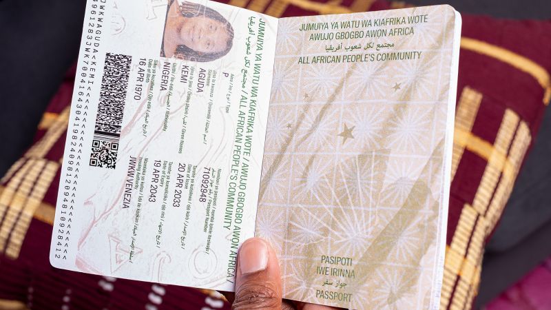 Color photograph of a hand holding an artist-designed passport