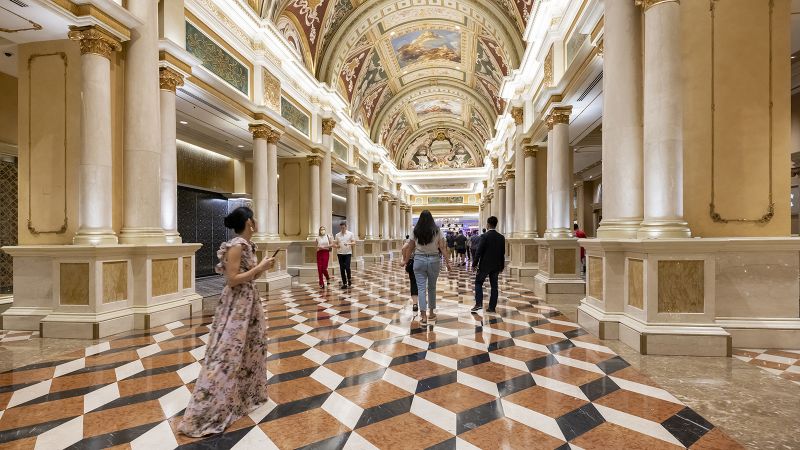 Color photograph of the interior of a Las Vegas hotel or casino, with three-dimesional looking square cube floors and a barrel vaulted ceiling painting with frescos