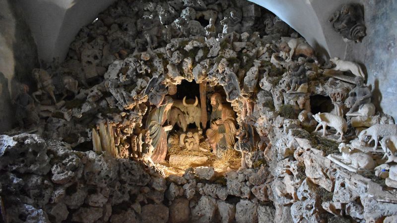 Color photograph of a painted limestone sculpture depicting the Catholic nativity