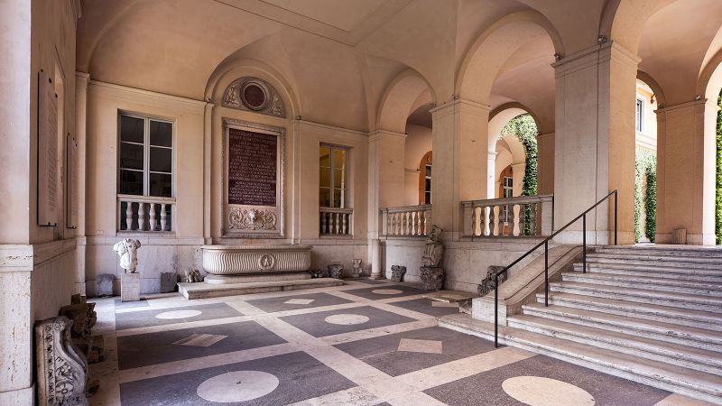 Color photograph of tiled floors, arched columns, and staircase that make up the interior entrance to AAR’s McKim Mead & White Building
