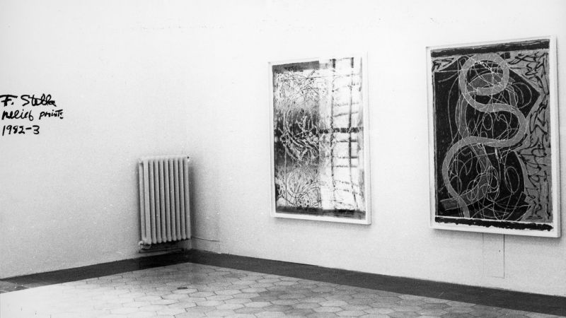Black and white photo of two large prints hanging on a gallery wall