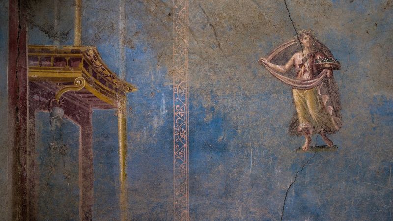Color photo of an ancient Roman wall painting with a mythological figure and an architectural element