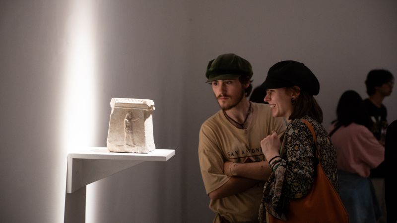 Two people look an an antique item