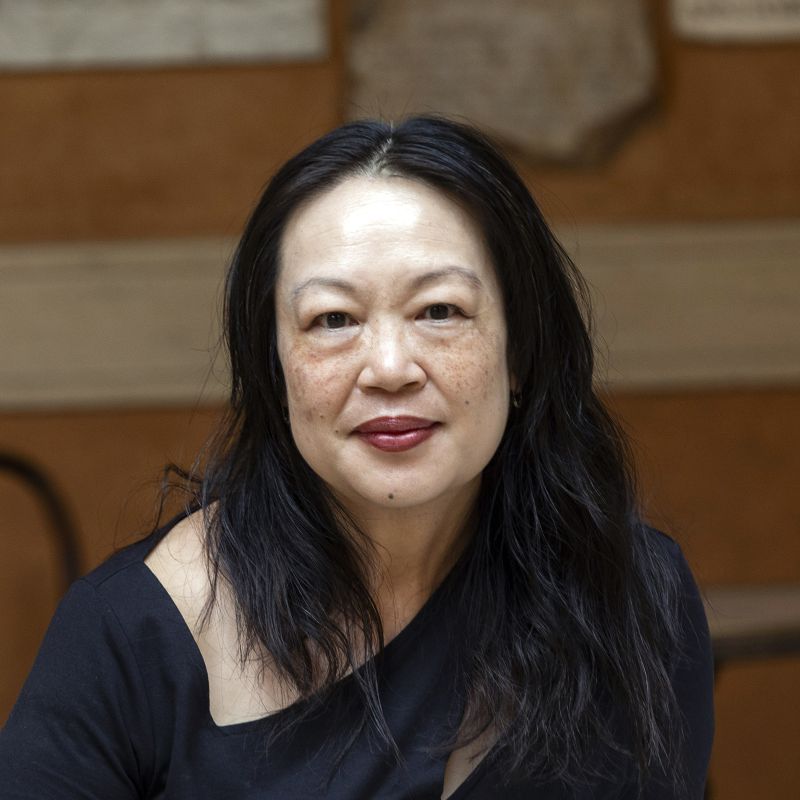 Color photograph of the head and shoulders of an Asian woman looking directly at the camera
