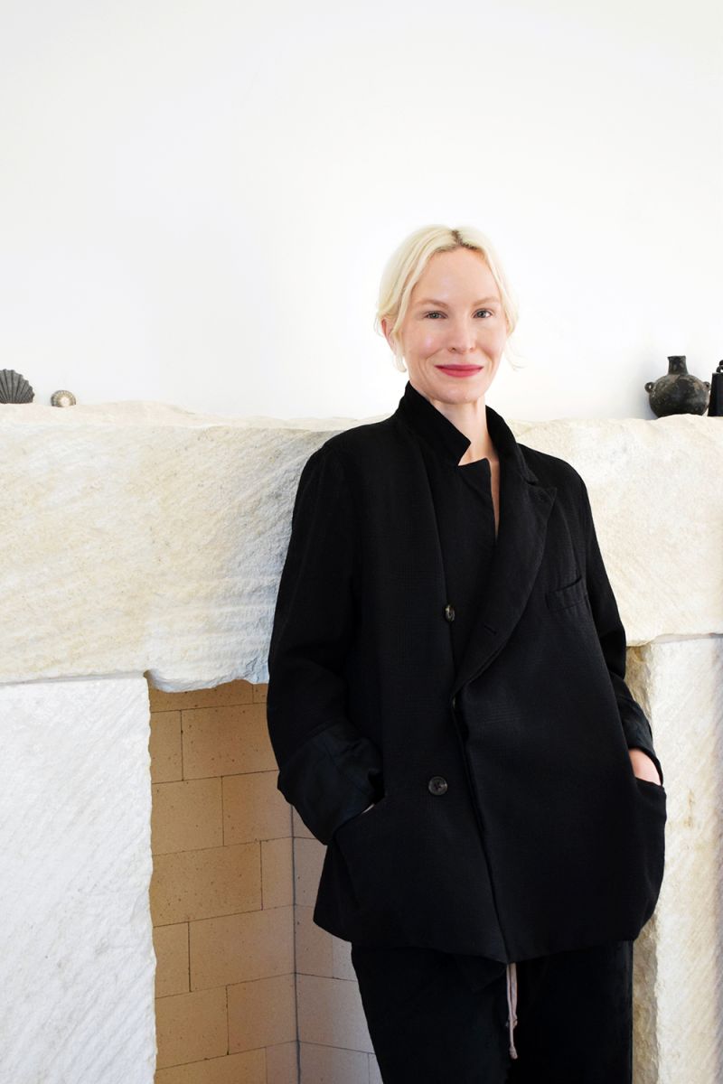 Color photo of a light skinned woman wearing all black and smiling at the camera