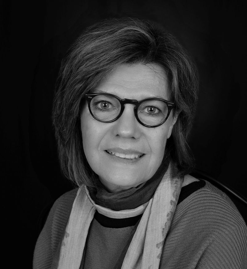 Black and white photograph of the head and shoulders of Carol Mancusi-Ungaro looking straight at the camera