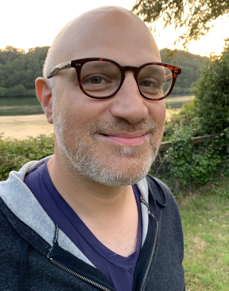 Color portrait of the head and shoulders of David Serlin wearing glasses and smiling