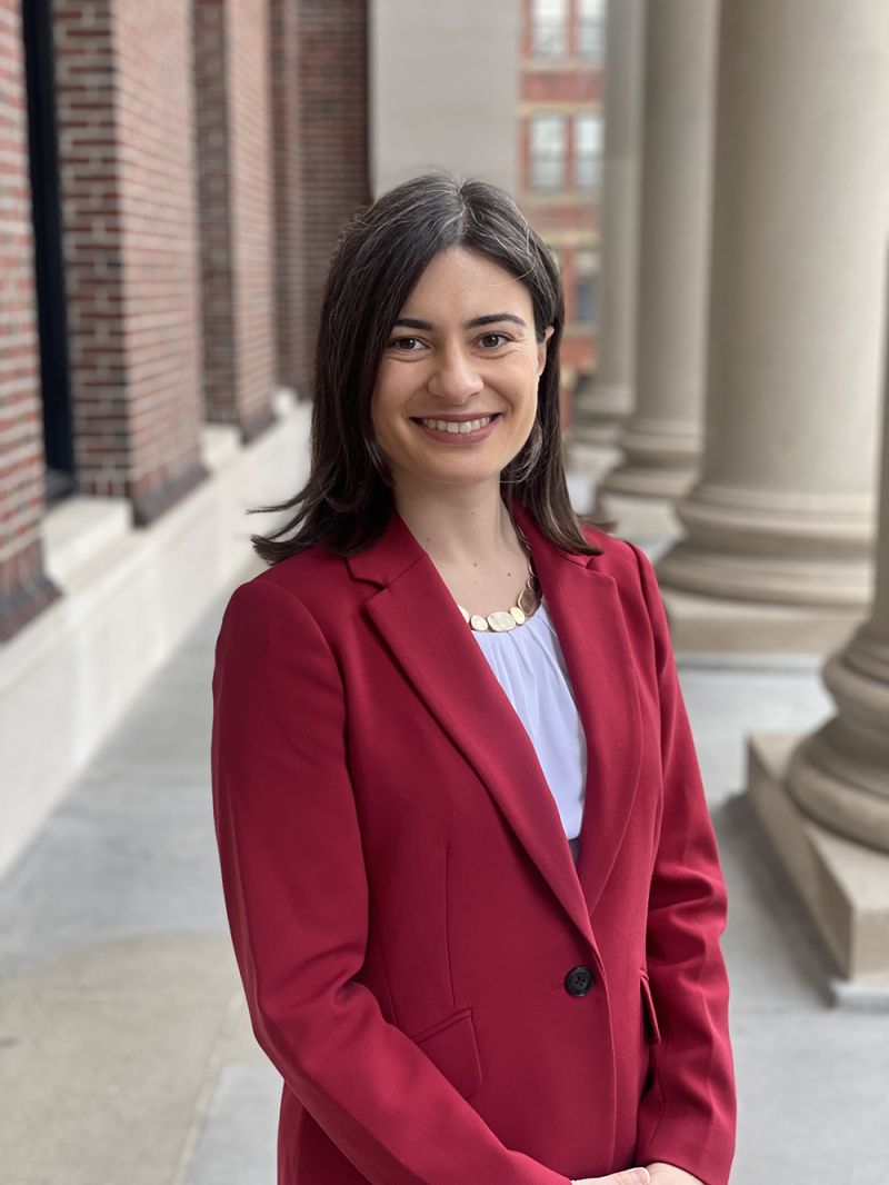 Color photo of a woman wearing a red blazer