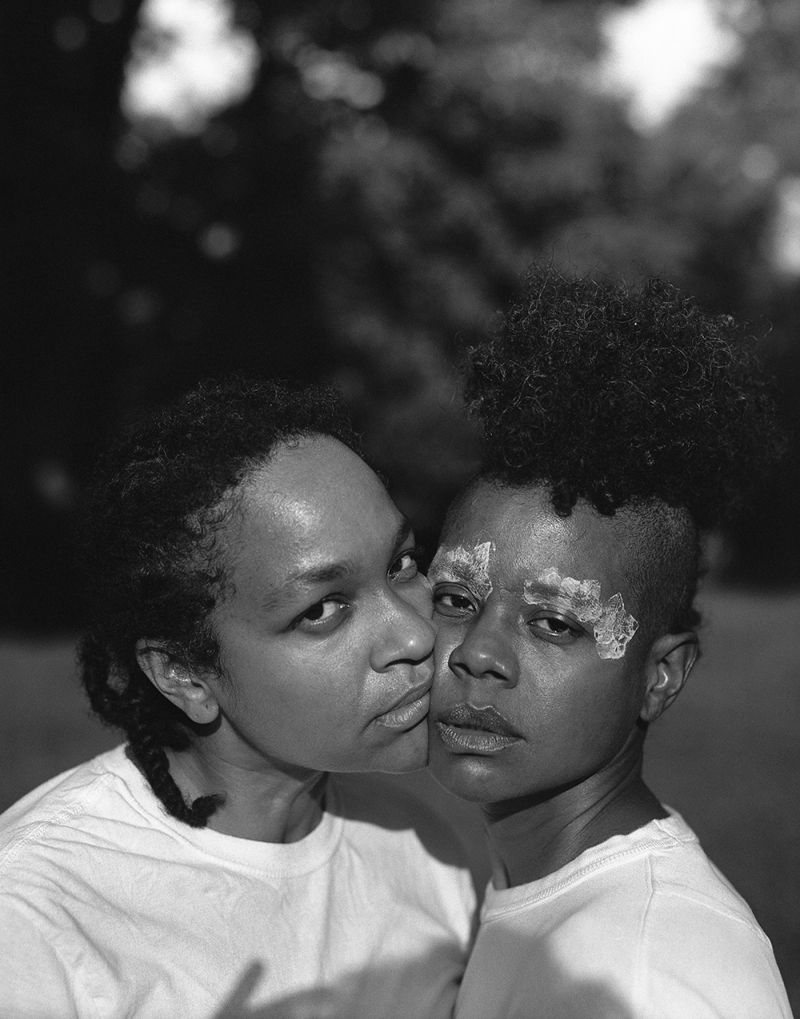 Black and white photograph of La Nietas de Nonó, showing the heads and shoulders of two women that are nearly embracing each other