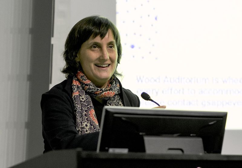 Color photograph of Laura Kurgan speaking from a lecture podium