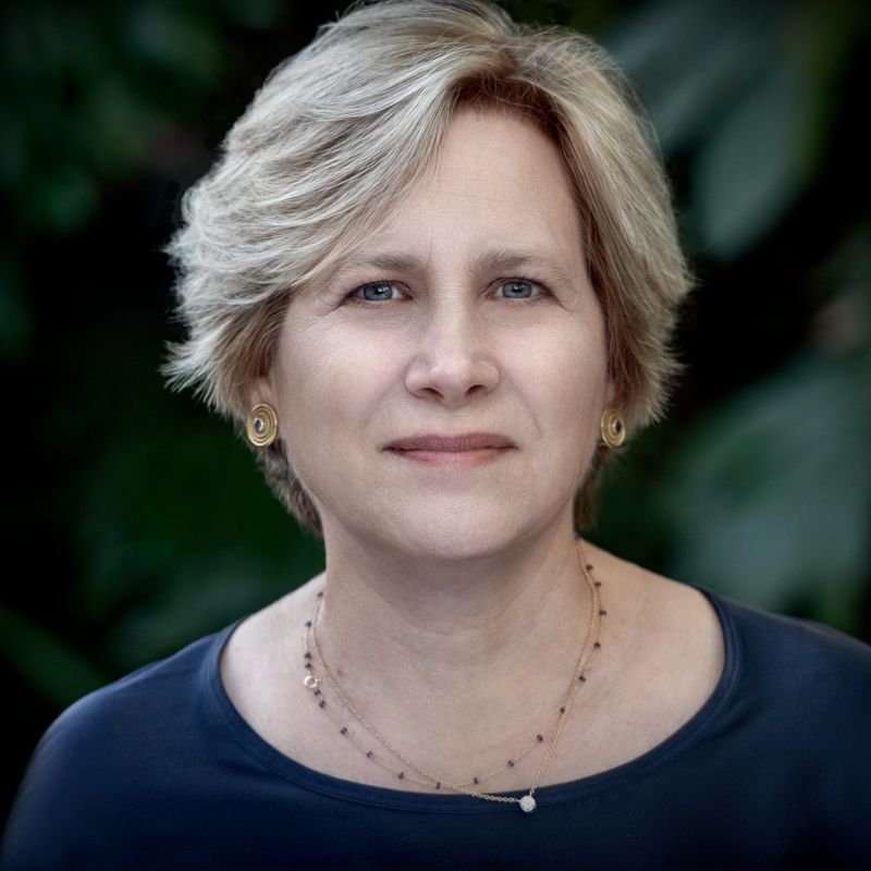 Color photograph of the head and shoulders of Marla Stone, a light skinned woman with blonde hair looking at the camera with a serious expression