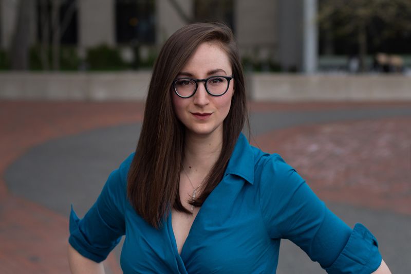 Color photograph of Tina Tallon standing in an outdoor plaza, with her hands on her hips